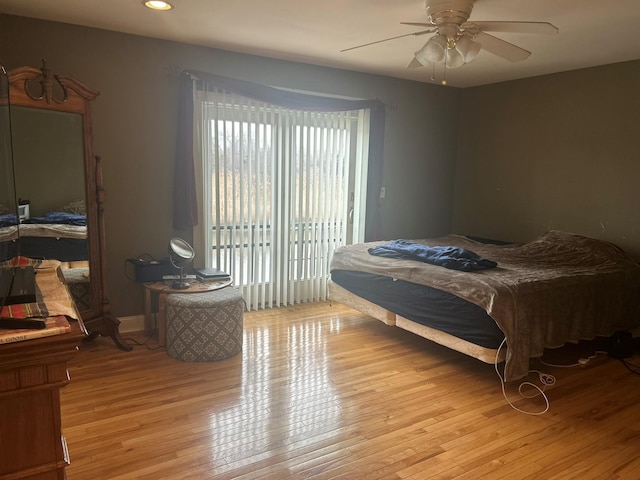 bedroom featuring access to exterior, light hardwood / wood-style floors, and ceiling fan