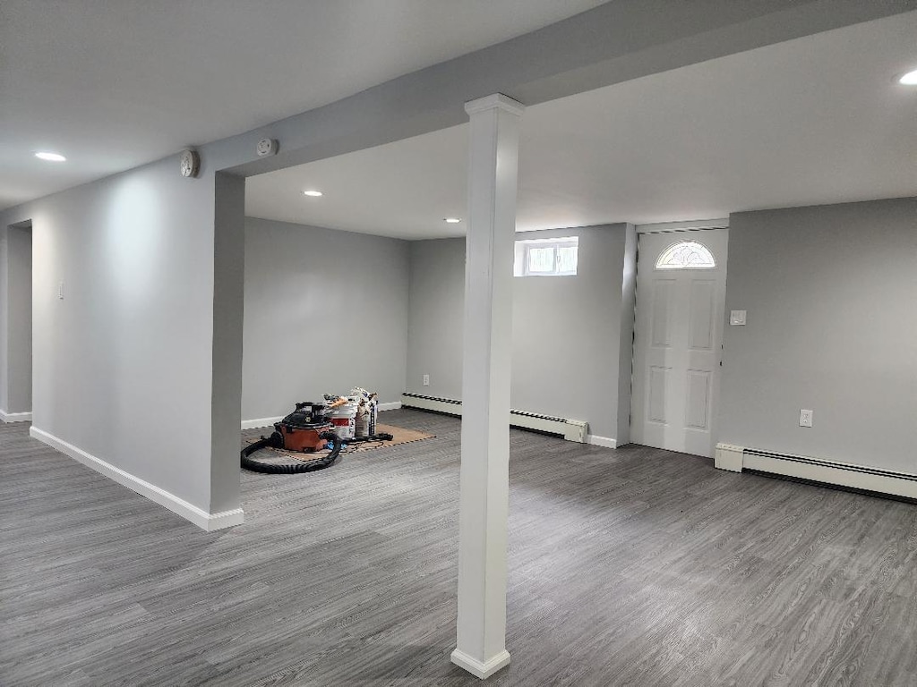 basement featuring hardwood / wood-style floors and a baseboard radiator