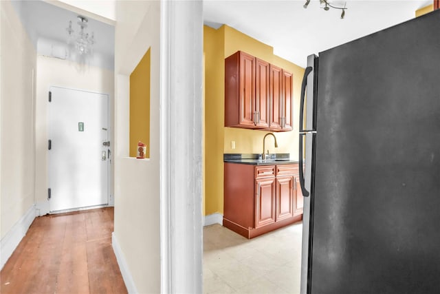 kitchen with black fridge, sink, and light hardwood / wood-style floors