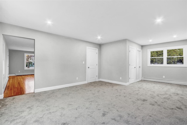 unfurnished room with carpet flooring and a baseboard radiator