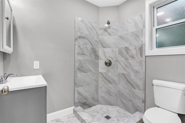 bathroom featuring vanity, toilet, and tiled shower