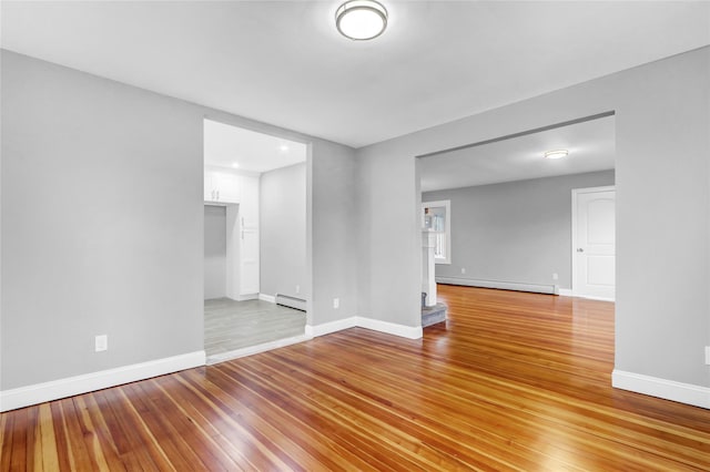 empty room with light hardwood / wood-style floors and baseboard heating