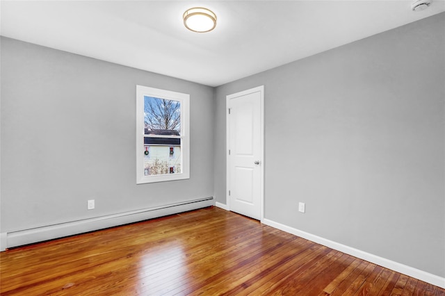 spare room with hardwood / wood-style flooring and a baseboard heating unit