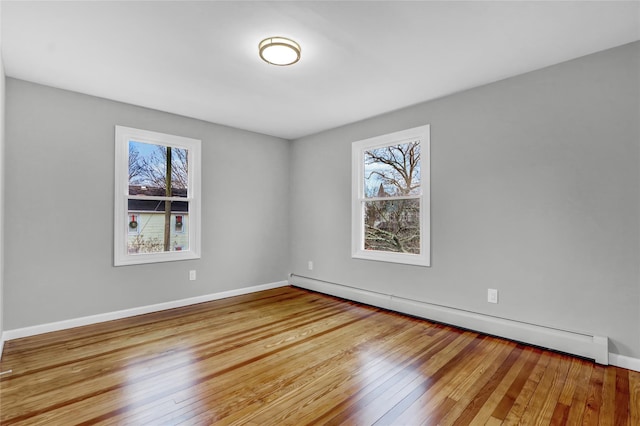 spare room featuring hardwood / wood-style floors and a baseboard radiator