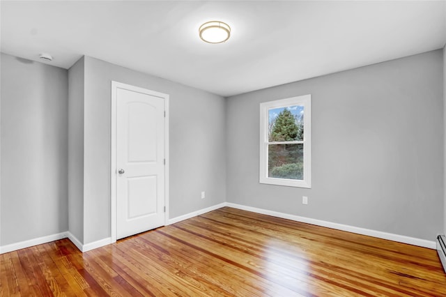 spare room featuring hardwood / wood-style floors and baseboard heating