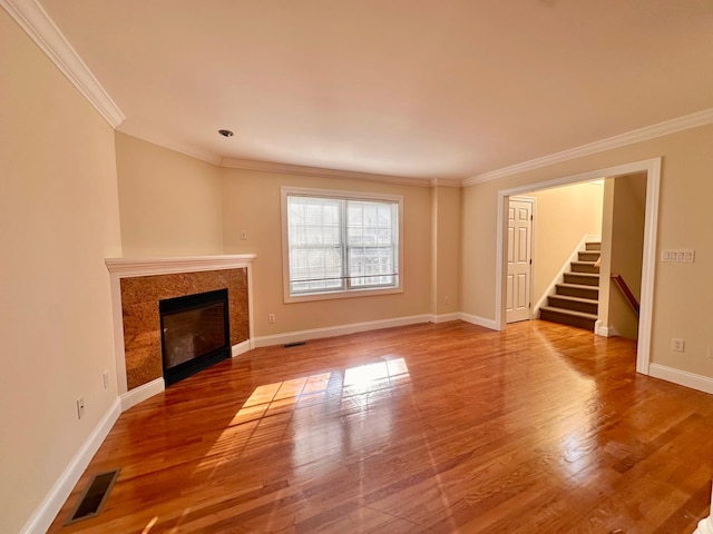 unfurnished living room featuring hardwood / wood-style flooring and ornamental molding