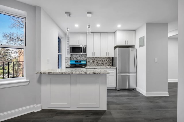 kitchen featuring appliances with stainless steel finishes, tasteful backsplash, light stone counters, decorative light fixtures, and white cabinets