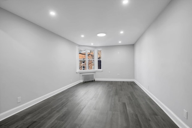 unfurnished living room featuring radiator heating unit and dark hardwood / wood-style floors