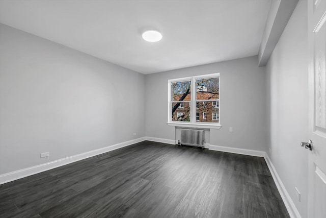 empty room featuring dark hardwood / wood-style flooring and radiator heating unit