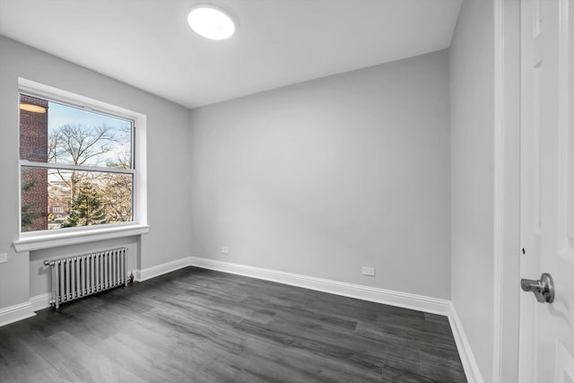 unfurnished room featuring radiator heating unit and dark wood-type flooring