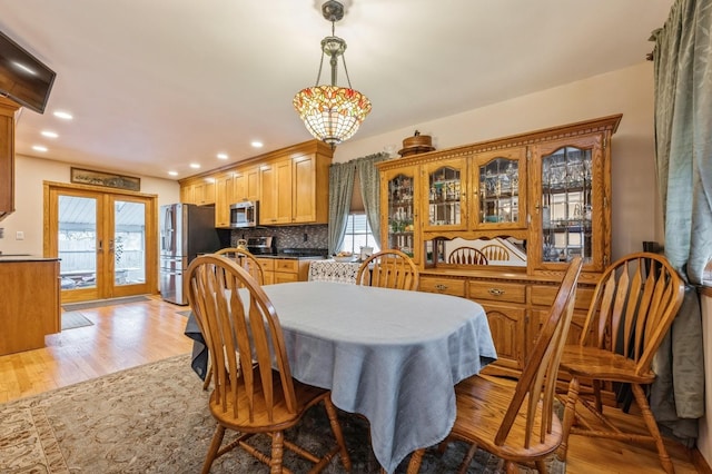 dining space with light hardwood / wood-style floors and french doors