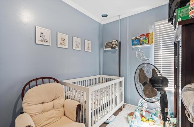 bedroom with a nursery area and ornamental molding