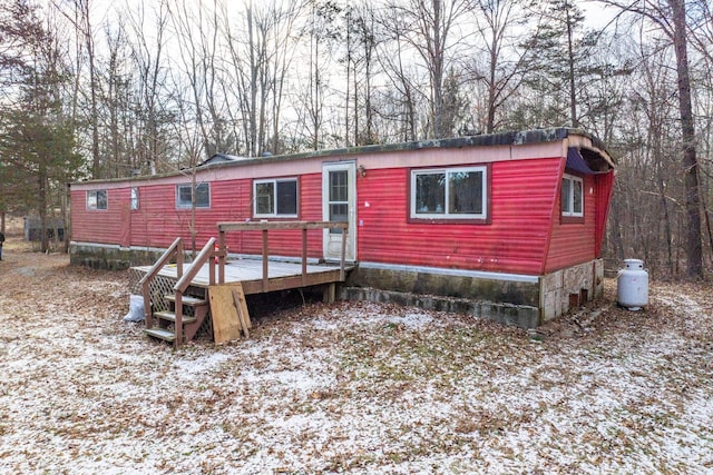 snow covered rear of property featuring a deck