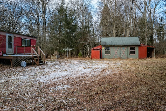 view of yard featuring an outdoor structure and a wooden deck