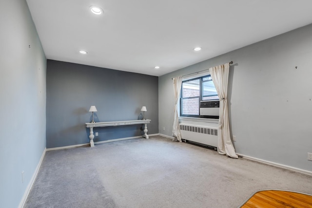 carpeted spare room with radiator and cooling unit