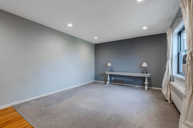 unfurnished room featuring wood-type flooring and radiator heating unit