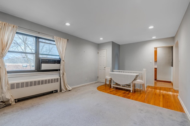 interior space with radiator heating unit, light colored carpet, and cooling unit