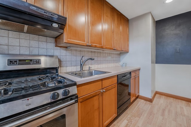 kitchen featuring light wood-type flooring, black dishwasher, stainless steel gas range oven, and sink