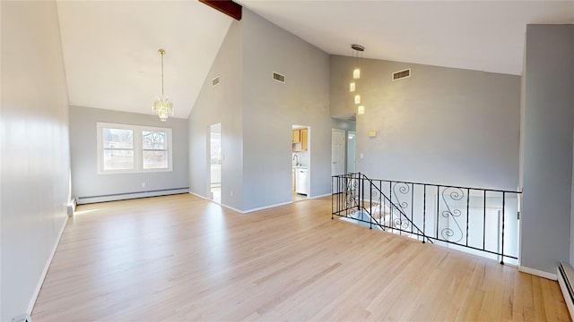 unfurnished room with an inviting chandelier, light hardwood / wood-style flooring, and a baseboard heating unit