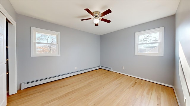 spare room featuring light hardwood / wood-style flooring, ceiling fan, and baseboard heating