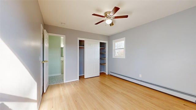 unfurnished bedroom with light wood-type flooring, ensuite bathroom, ceiling fan, and baseboard heating