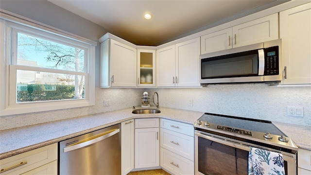 kitchen with white cabinetry, appliances with stainless steel finishes, sink, and decorative backsplash