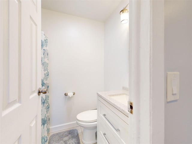 bathroom with vanity, tile patterned flooring, and toilet