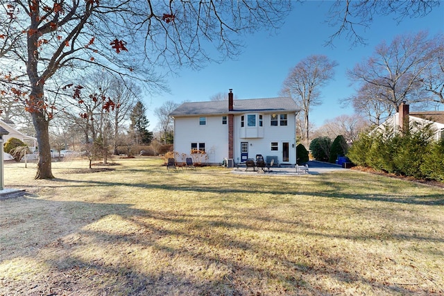 back of property featuring a lawn and a patio