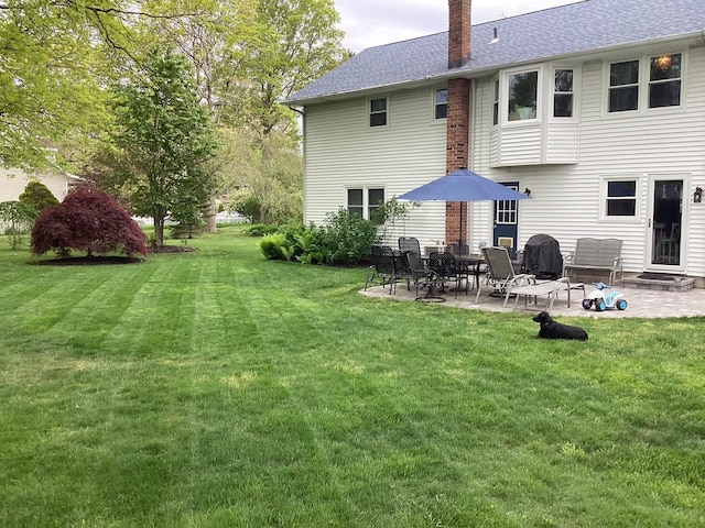 rear view of property with a lawn and a patio area