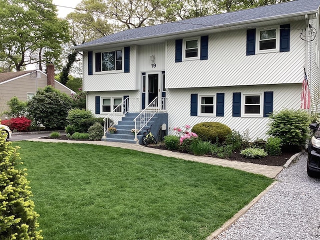 bi-level home featuring a front yard and a shingled roof