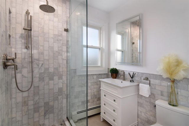 bathroom featuring vanity, toilet, a tile shower, and a baseboard heating unit