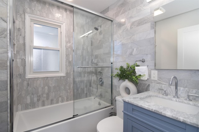 full bathroom featuring decorative backsplash, vanity, toilet, and bath / shower combo with glass door