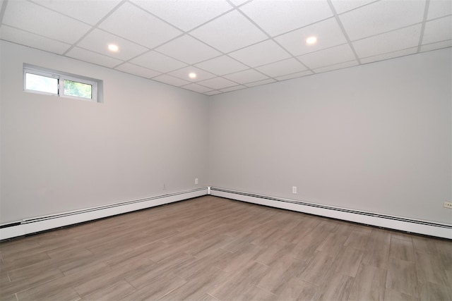 basement featuring a drop ceiling and light wood-type flooring