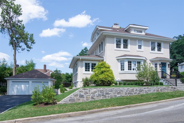 view of front of property with a garage and an outdoor structure