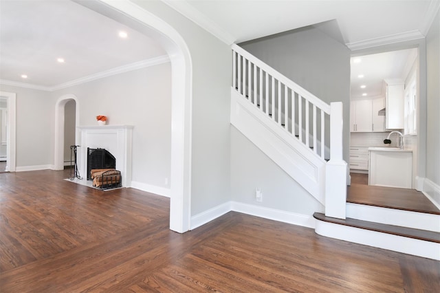 staircase with hardwood / wood-style floors and crown molding