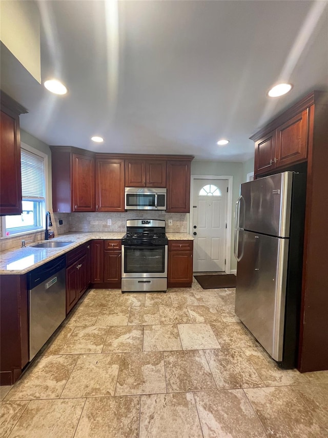 kitchen with backsplash, stainless steel appliances, and sink