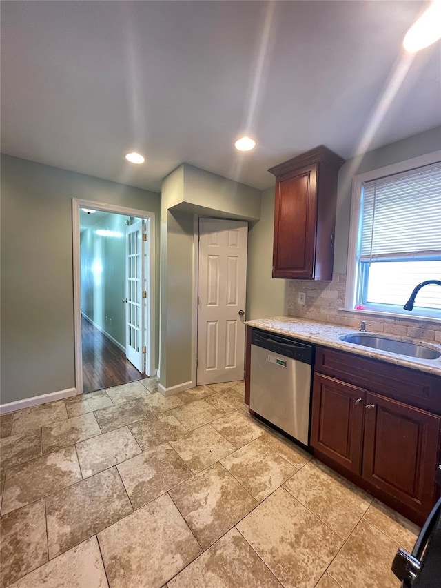 kitchen featuring backsplash, dishwasher, and sink