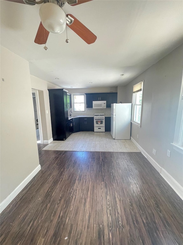 unfurnished living room with hardwood / wood-style flooring, a healthy amount of sunlight, and sink