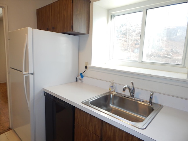 kitchen featuring dishwasher, white fridge, light parquet floors, and sink