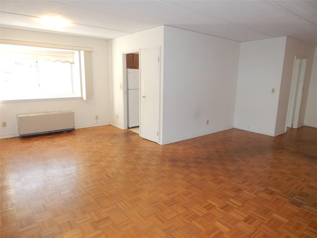 unfurnished room with parquet flooring and radiator