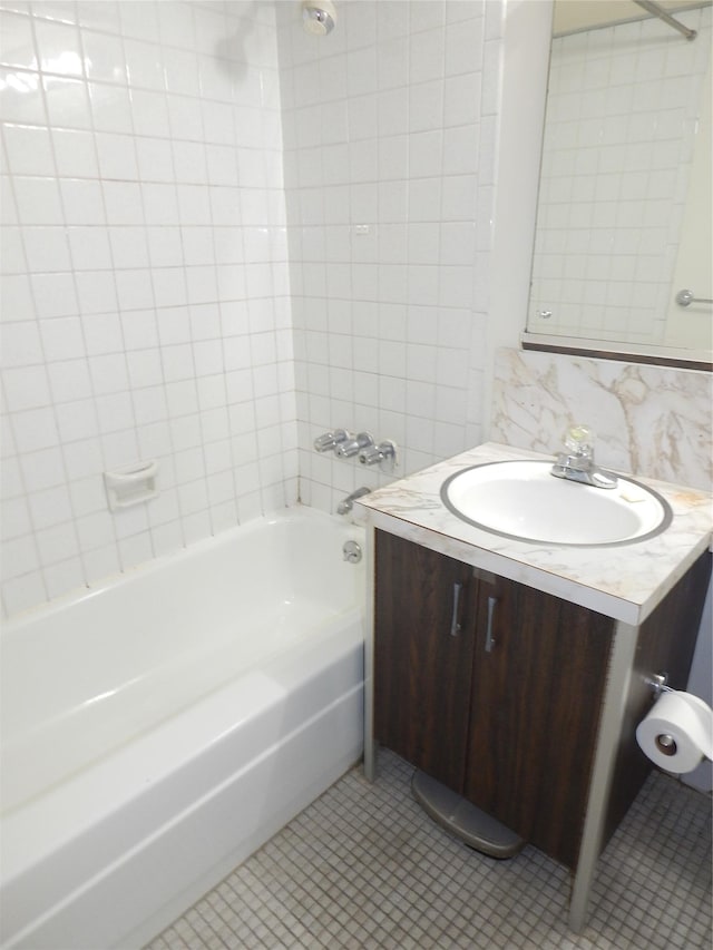 bathroom with decorative backsplash, tile patterned flooring, vanity, and tiled shower / bath