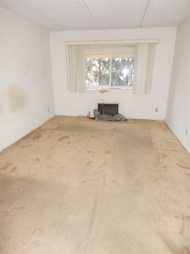 unfurnished living room featuring carpet and an AC wall unit