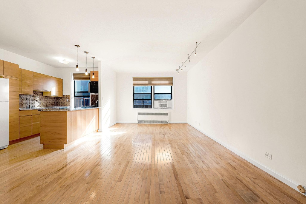 unfurnished living room featuring light hardwood / wood-style floors and radiator