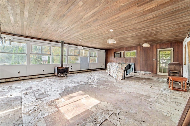 interior space with multiple windows, wooden walls, baseboard heating, and wooden ceiling