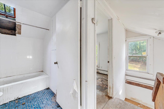 bathroom featuring a washtub, vaulted ceiling, and baseboard heating