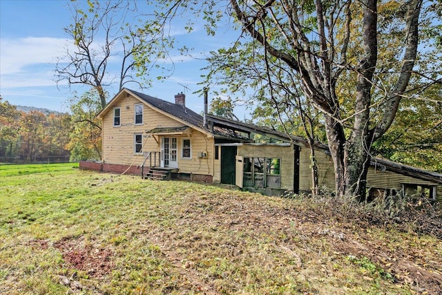 rear view of house featuring a yard