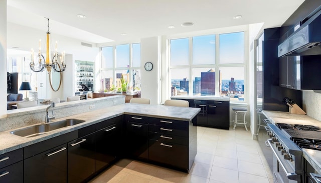 kitchen featuring light stone countertops, sink, light tile patterned floors, and pendant lighting