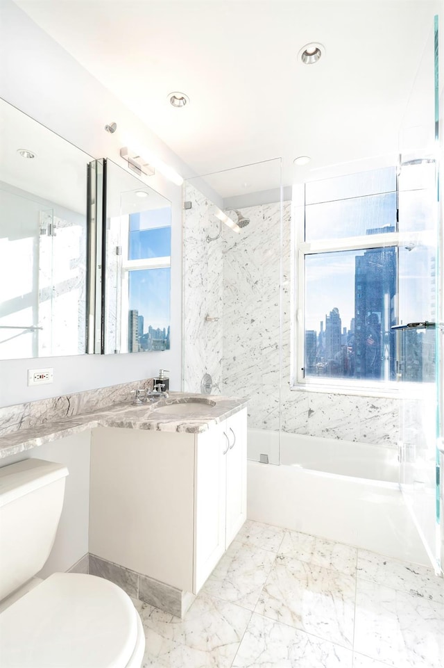 full bathroom featuring vanity, tiled shower / bath combo, and toilet