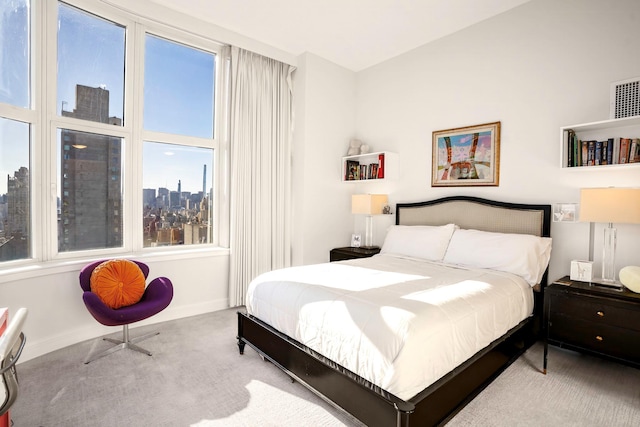 bedroom with light carpet and multiple windows