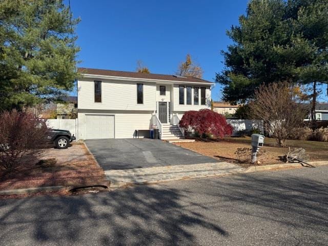 bi-level home with an attached garage and aphalt driveway